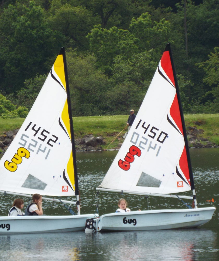 Three children learning to sail in Laser Bug dinghies